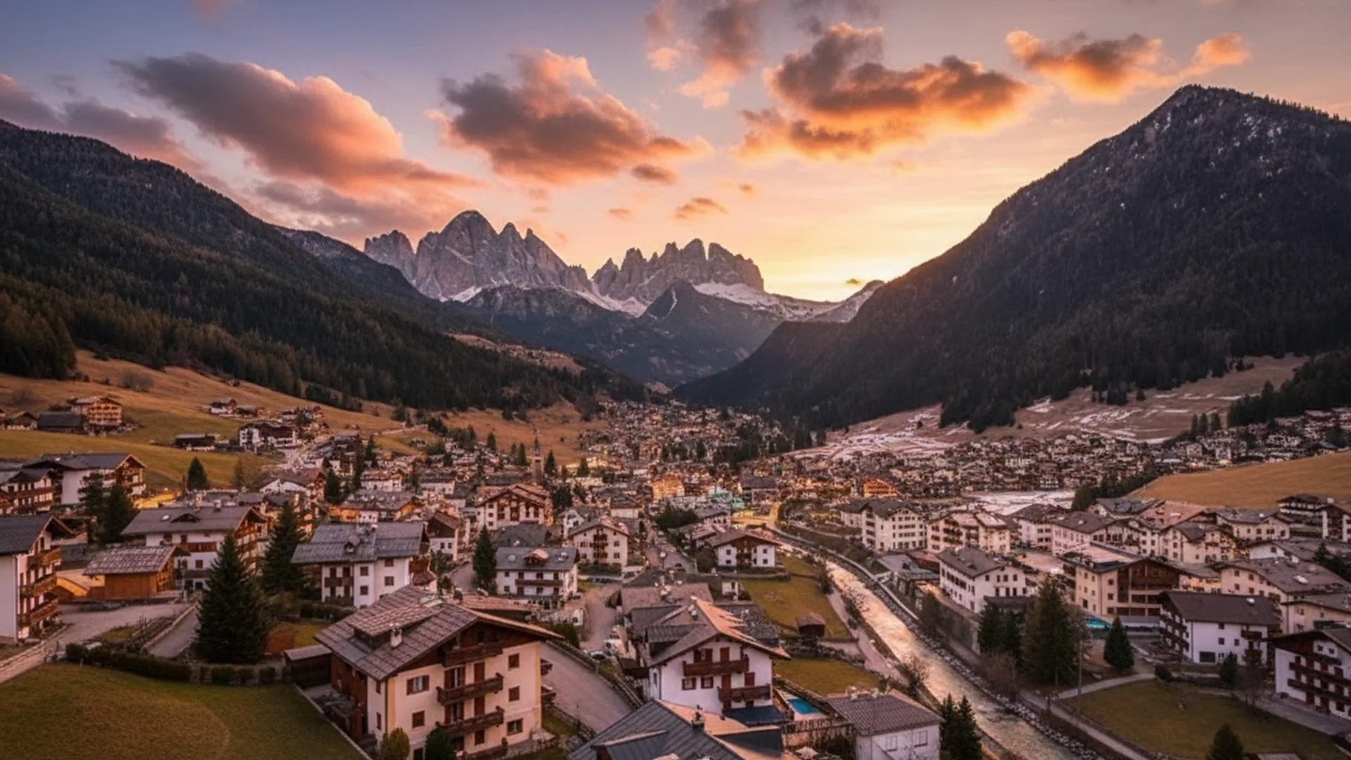 Un paese della Val di Fassa al tramonto, fra i boschi e le cime dolomitiche